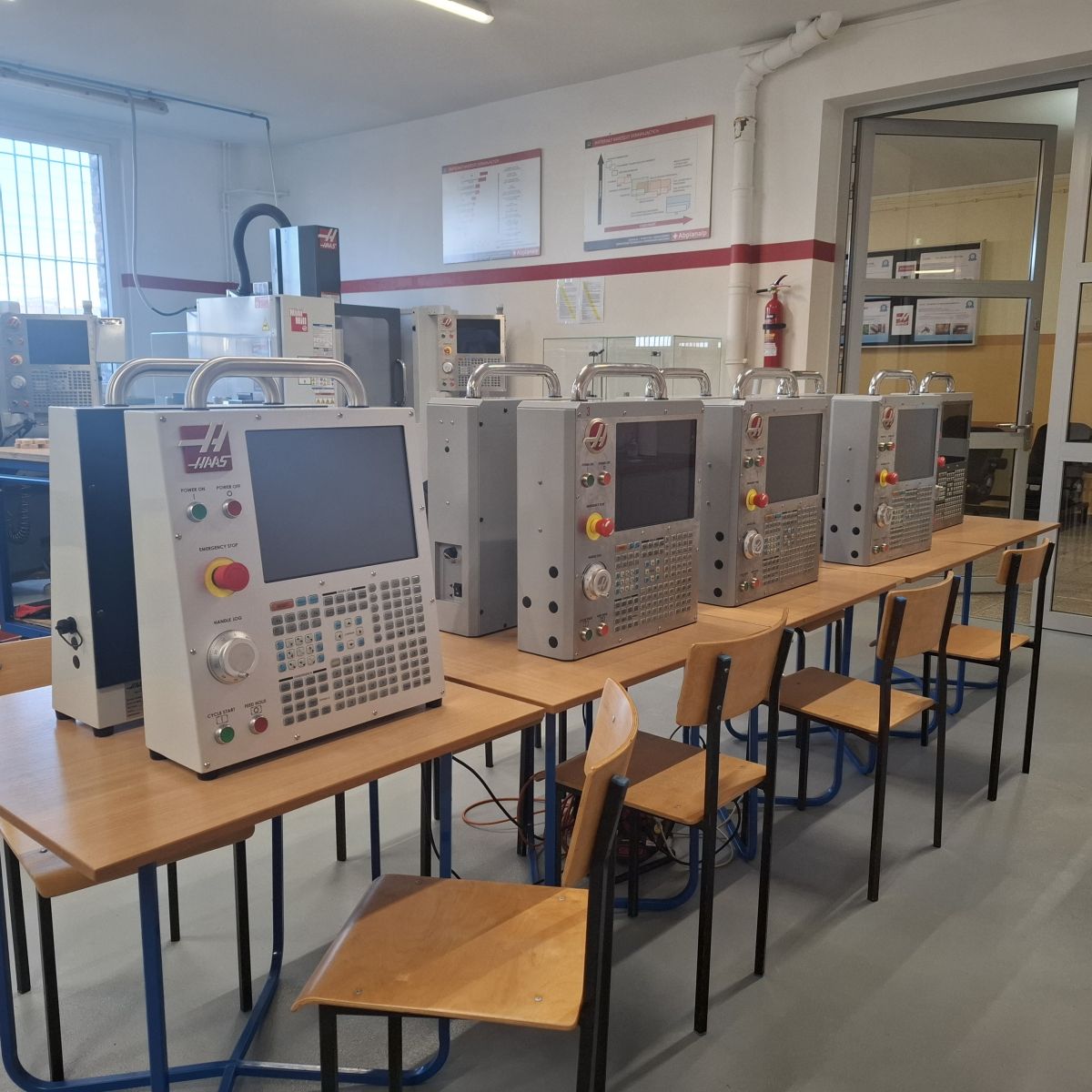 stoły z urządzeniami z komputerami, krzesła przy stołach