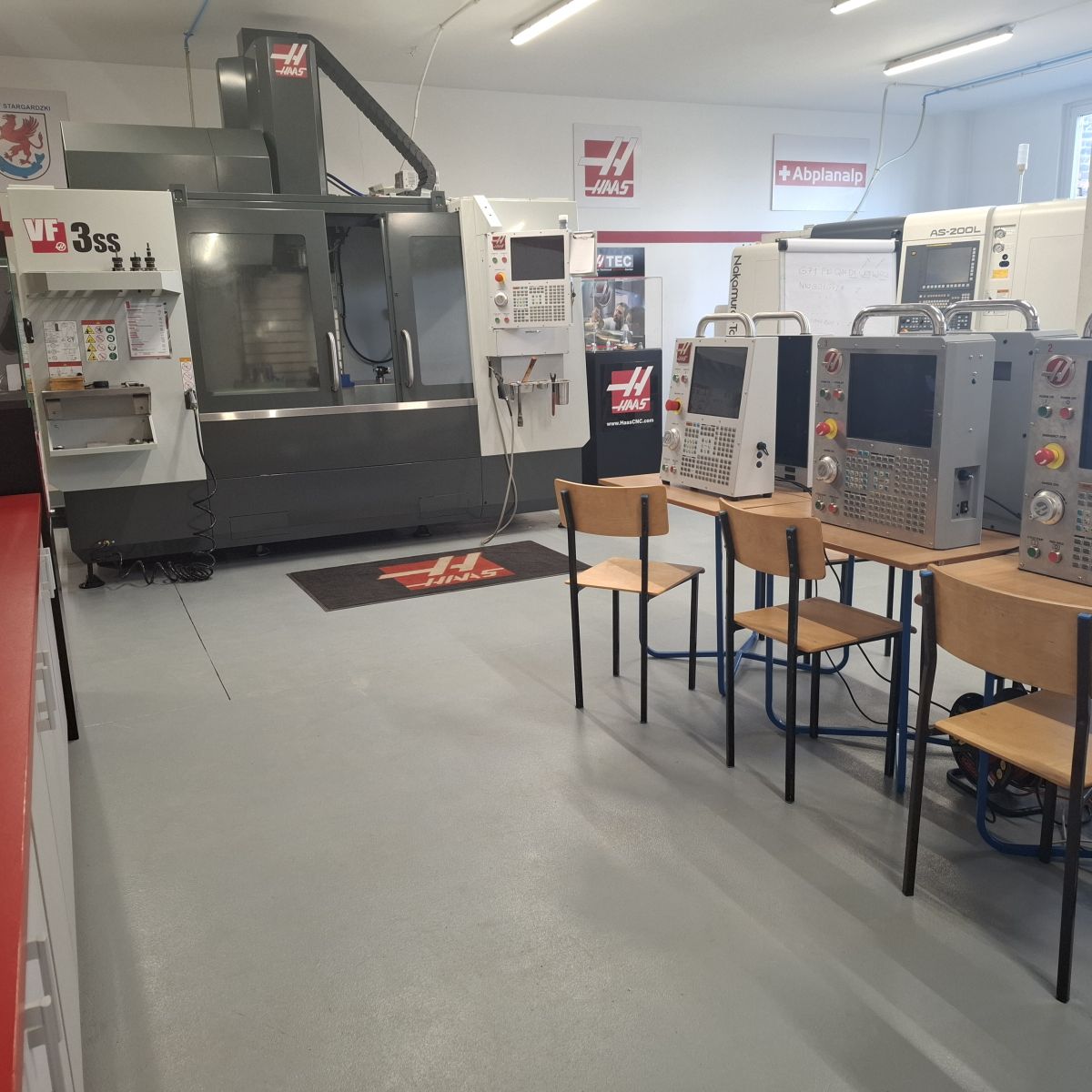 stoły z urządzeniami z komputerami, krzesła przy stołach